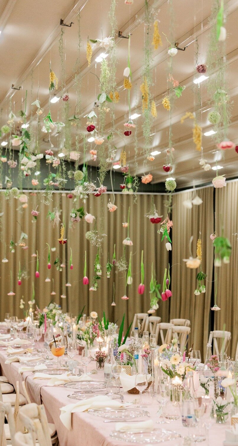 A long table beneath suspended flowers